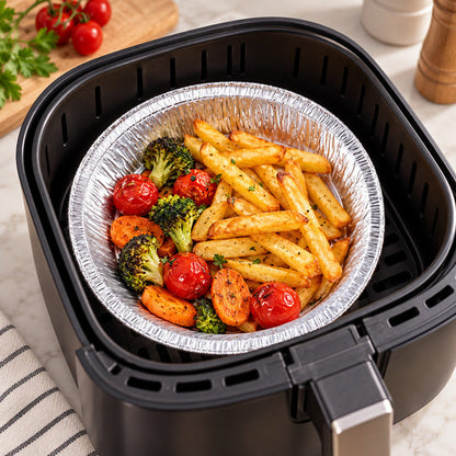 Air fryer foil bowl holding cooked fries and vegetables