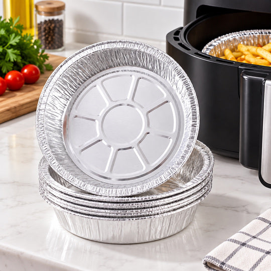 Nested disposable air fryer foil bowls beside an air fryer