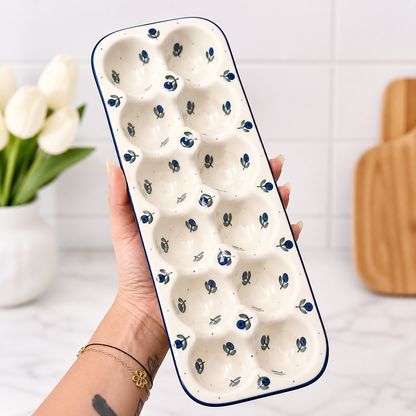 Hand holding blue berry ceramic egg tray